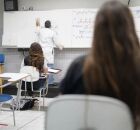 Professor em sala de universidade dando aula.