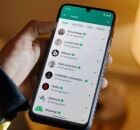 Pessoa mexendo no WhatsApp em celular.