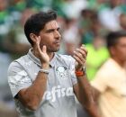 T&eacute;cnico do Palmeiras aplaude &agrave; beira do campo durante partida, uniforme cinza de comiss&atilde;o t&eacute;cnica e torcida ao fundo