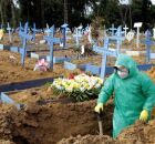 Coveiro com roupa de prote&ccedil;&atilde;o em cemit&eacute;rio, durante per&iacute;odo de pandemia, no Brasil.