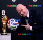 Presidente da FIFA com a bola e a ta&ccedil;a da Copa do Mundo de 2026 