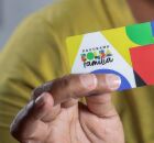 Homem segurando cart&atilde;o do Bolsa Fam&iacute;lia.