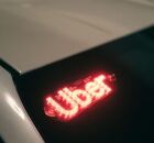 Carro com identifica&ccedil;&atilde;o do aplicativo da Uber.