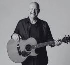 Brian Doerksen em retrato promocional segurando um viol&atilde;o. 