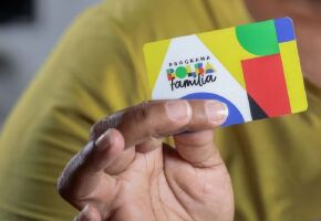 Homem segurando cart&atilde;o do Bolsa Fam&iacute;lia.