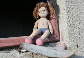 Boneca de menina em janela.