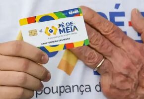 Pessoa segurando cart&atilde;o do P&eacute;-de-Meia ao lado da m&atilde;o de Lula.