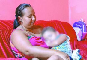 M&atilde;e segura crian&ccedil;a no colo em caso relacionado &agrave; troca de beb&ecirc;s.