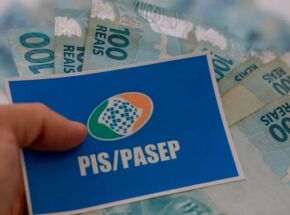 Pessoa segurando cart&atilde;o do PIS/Pasep com dinheiro do abono.