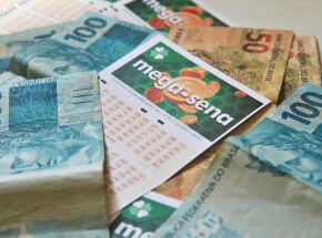 Cartelas da Mega-Sena e dinheiro.