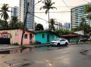As casas que a prefeitura quer remover constrastam com os pr&eacute;dios ao redor  