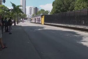 Passageiros no Recife esperando ônibus em parada.