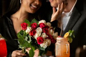 Mulher recebendo um buqu&ecirc; de rosas do namorado.