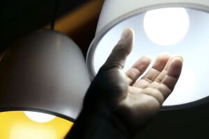 Pessoa mexendo em l&acirc;mpada.