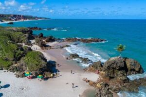 Tambaba com fal&eacute;sias e mar calmo compondo o cen&aacute;rio preservado da regi&atilde;o.