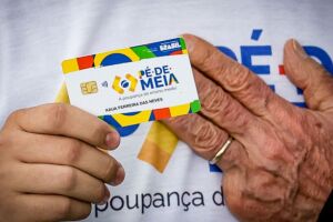 M&atilde;o do presidente Lula e pessoa segurando cart&atilde;o do P&eacute;-de-Meia.