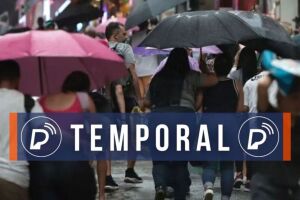Pessoas se abrigando das precipita&ccedil;&otilde;es com guarda-chuvas.