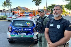 Policial Civil e Militar juntos ao lado de viatura da PMPE.