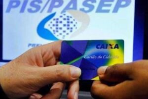 Pessoas segurando cart&atilde;o da Caixa Econ&ocirc;mica e imagem do PIS/Pasep de fundo.