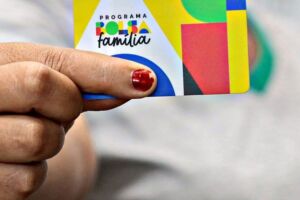 Mulher segurando cart&atilde;o do Bolsa Fam&iacute;lia.