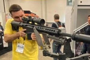 Fl&aacute;vio Bolsonaro segurando arma.