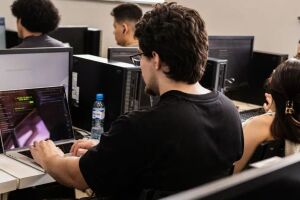 Jovens realizando cursos em computadores.
