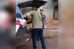 Momento em que suspeitos s&atilde;o colocados na viatura.