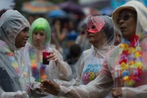 Pessoas brincando Carnaval na chuva.