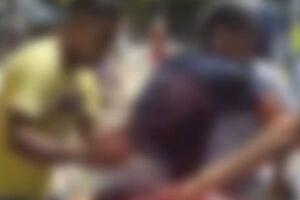 Momento em que uma das v&iacute;timas &eacute; levada, por populares, para unidade de sa&uacute;de.