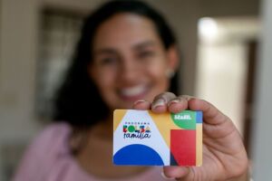 Mulher segurando cart&atilde;o do Bolsa Fam&iacute;lia.