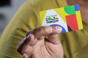 Homem segurando cart&atilde;o do Bolsa Fam&iacute;lia.