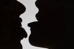 Silhuetas de pessoas se beijando.