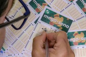 Pessoa marcando cartela da Mega-Sena.