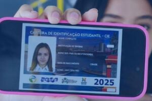 Pessoa segurando celular com documento digital da Carteira Estudantil da RMR.