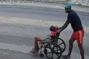 Filho empurrando pai morto na cadeira de rodas. 