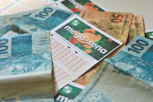 Cartelas da Mega-Sena e dinheiro.