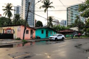As casas que a prefeitura quer remover constrastam com os pr&eacute;dios ao redor  