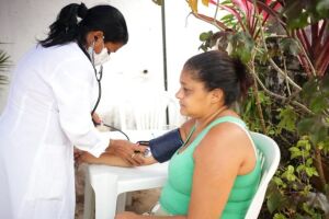 Paciente sendo examinada por uma profissional da sa&uacute;de que atende a iniciativa disponibilizada no munic&iacute;pio.