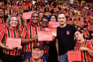 Presidente do Sport, de camisa preta, entregando certificados da parceria com as escolas.