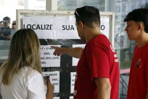 Eleitores consultando se&ccedil;&atilde;o de vota&ccedil;&atilde;o.