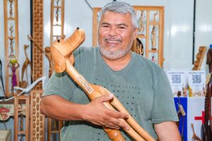 O artista Marcos de Sert&acirc;nia exibe uma de suas esculturas em madeira.