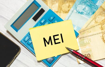 Calculadora, dinheiro e papel escrito MEI.