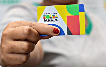 Mulher segurando cart&atilde;o do Bolsa Fam&iacute;lia.