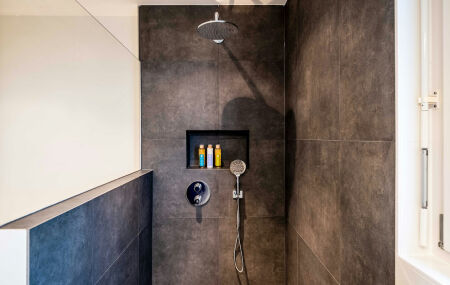 Banheiro com chuveiro walk-in: aus&ecirc;ncia de box de vidro, piso cont&iacute;nuo e espa&ccedil;o integrado.