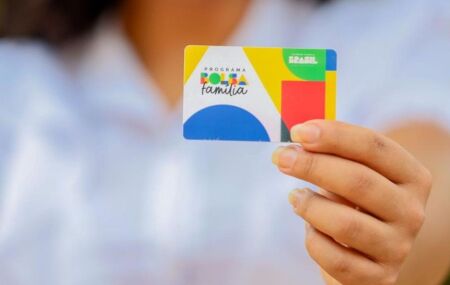 Mulher segurando cart&atilde;o do Bolsa Fam&iacute;lia.