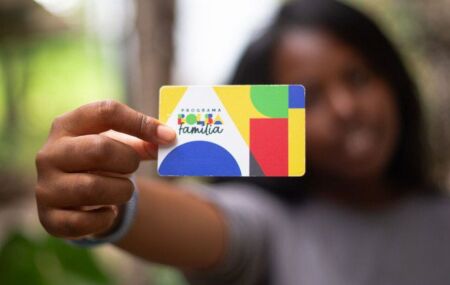 Mulher seguando cart&atilde;o do Bolsa Fam&iacute;lia.