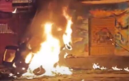 Carro que colidiu com poste pegando fogo.