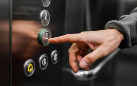 Pessoa apertando bot&otilde;es de elevador. 