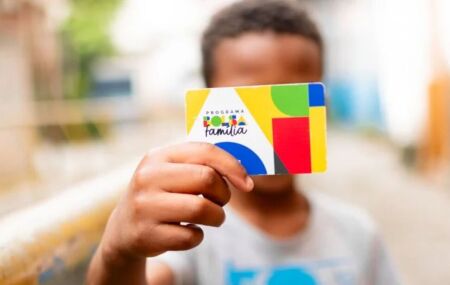 Menino segurando cart&atilde;o do Bolsa Fam&iacute;lia.