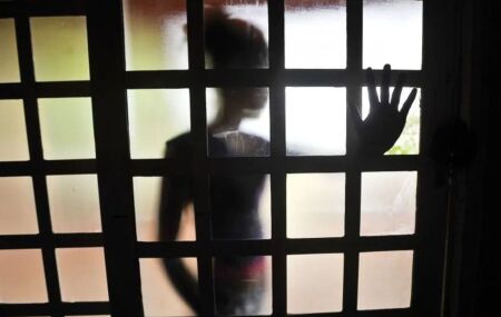 Pessoa com m&atilde;o em porta de vidro.